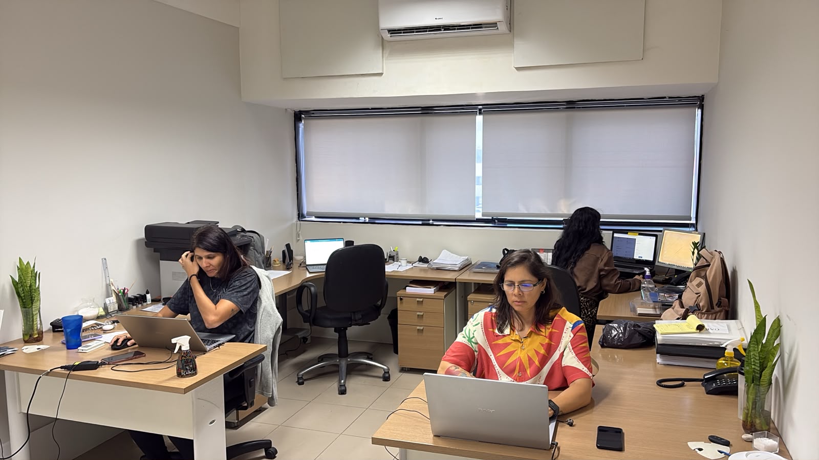 Equipe do Grupo Visão trabalhando no escritório em atendimento aos clientes